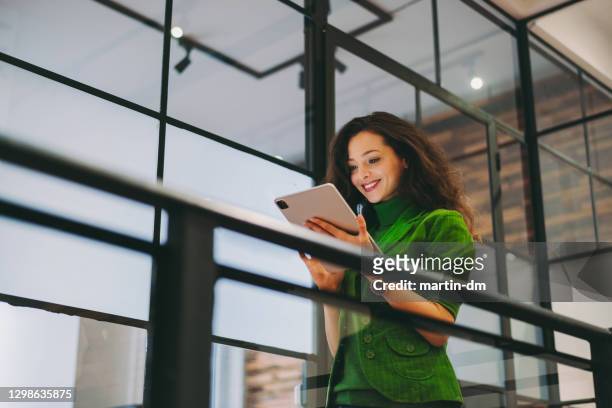 empresária usando tablet digital no escritório - vestido verde - fotografias e filmes do acervo