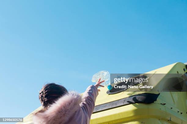 cute girl throwing a plastic bottle into the dumpster - kid throwing stock pictures, royalty-free photos & images