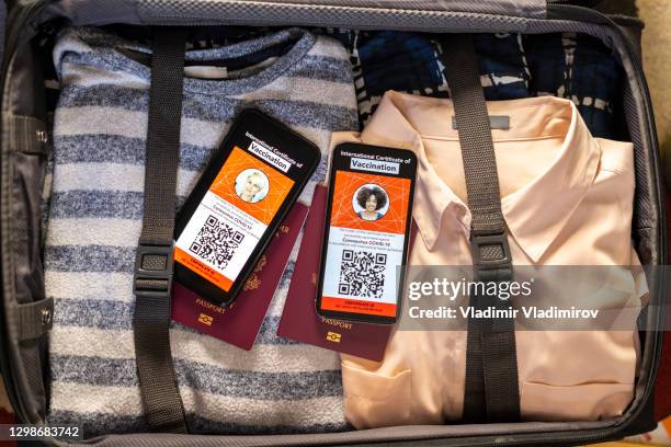 internationale impfbescheinigungen für covid-19 und pässe im koffer - impfpass reisedokument stock-fotos und bilder