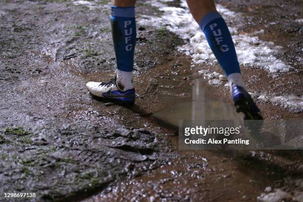 Peterborough player collects a ball from a muddy puddle during the Sky Bet League One match between Peterborough United and Bristol Rovers at Weston...