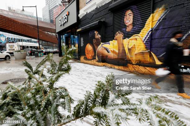 People walk by a mural memorializing Kobe Bryant and his daughter Gianna across from the Barclays Center on the first anniversary of their death on...