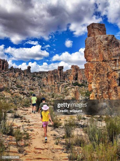 rear view three children walking between spectacular rock formations with dramatic sky - western cape province stock pictures, royalty-free photos & images