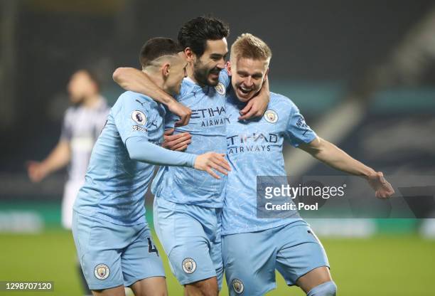 Ilkay Guendogan of Manchester City celebrates with Oleksandr Zinchenko and Phil Foden after scoring their team's first goal during the Premier League...