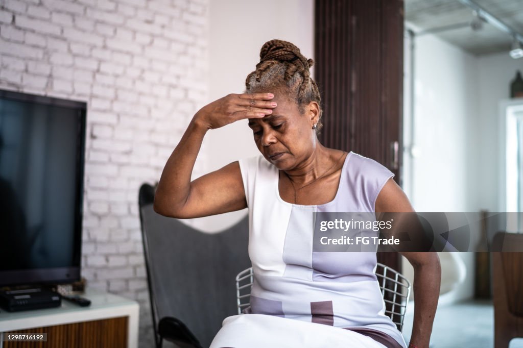 Mature woman with headache at home