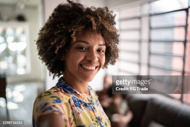 young woman taking a selfie at home - woman selfie stock pictures, royalty-free photos & images