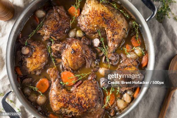 directly above shot of meat in bowl on table - coq au vin stock-fotos und bilder