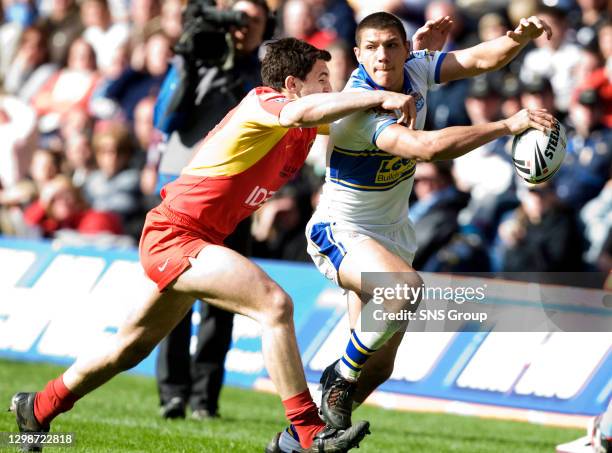 Leeds Rhinos ae Ryan Hall keeps the ball away from tackler Steve Bell........