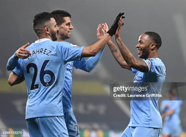 Raheem Sterling of Manchester City celebrates with Riyad Mahrez and Rodri after scoring their team's fifth goal during the Premier League match...