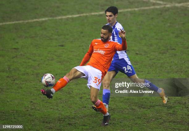 Kevin Stewart of Blackpool stretches for the ball ahead of Alex Perry of Wigan Athletic battle during the Sky Bet League One match between Wigan...