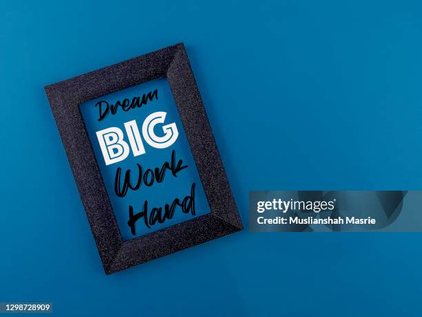 dream big, work hard quotes inside the picture frame border with blue background. - dream big stockfoto's en -beelden