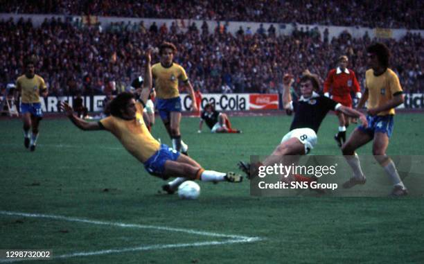V SCOTLAND.Brazilian defender Paizza slides in to tackle Scotland's kenny Dalglish