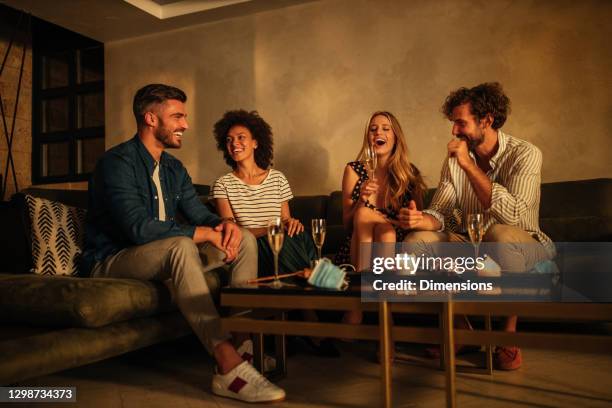 quelle meilleure façon de passer un week-end. couples s’asseyant sur le sofa et ayant le dîner de sushi - apéritif photos et images de collection