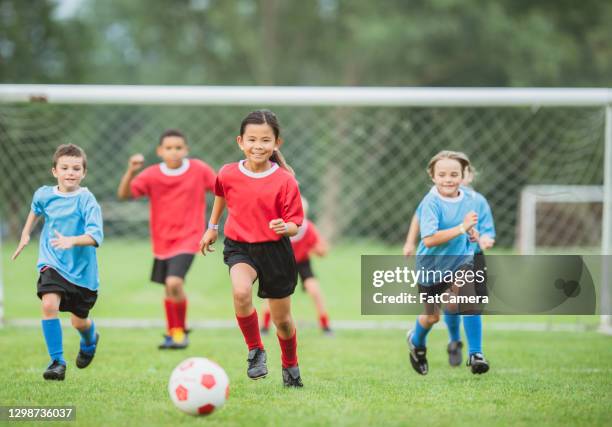 run for the ball! - kids soccer team stock pictures, royalty-free photos & images