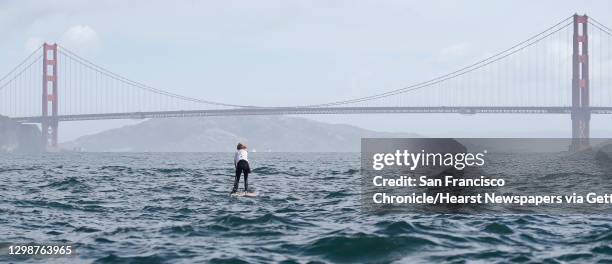 First place finisher Casper Steinfath approaches the Golden Gate Bridge during the Red Bull Heavy Water stand-up paddleboard race in San Francisco,...