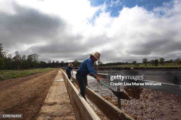 Molly and Jemima Penfold clean out feeding troughs at 'Mamaree' on January 19, 2021 in Meandarra, Australia. COVID-19 and the recent Chinese export...