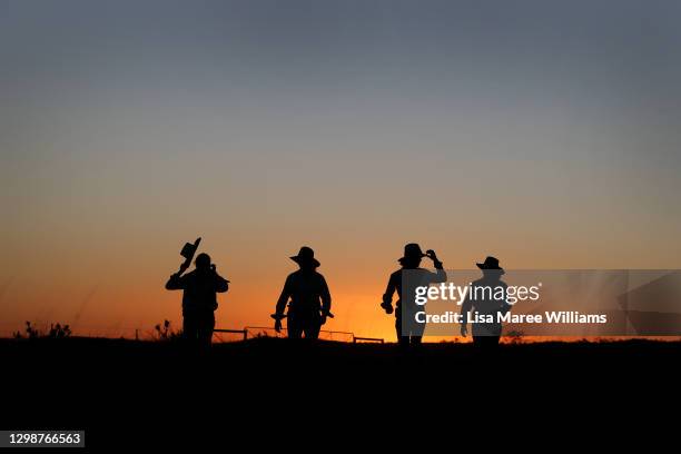 Sisters Matilda, Jemima, Bonnie and Molly Penfold walk through an open paddock as the sun sets at Old Bombine on January 19, 2021 in Meandarra,...