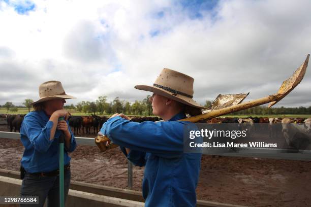 Molly and Jemima Penfold take a break after clearing out feeding troughs at 'Mamaree' on January 19, 2021 in Meandarra, Australia. COVID-19 and the...