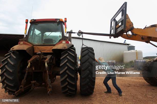 Jemima Penfold manoeuvres a tyre onto a tractor at 'Old Bombine' on January 18, 2021 in Meandarra, Australia. COVID-19 and the recent Chinese export...