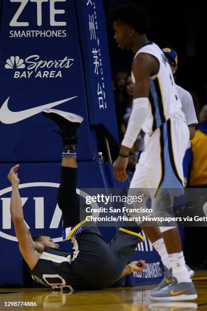 Golden State Warriors guard Stephen Curry falls during the second half of an NBA basketball game between the Golden State Warriors and Memphis...