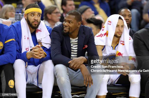Warriors' Kevin Durant, joins fellow players Javale McGee, 1 and Stephen Curry, 30 on the bench as the Golden State Warriors take on the Sacramento...