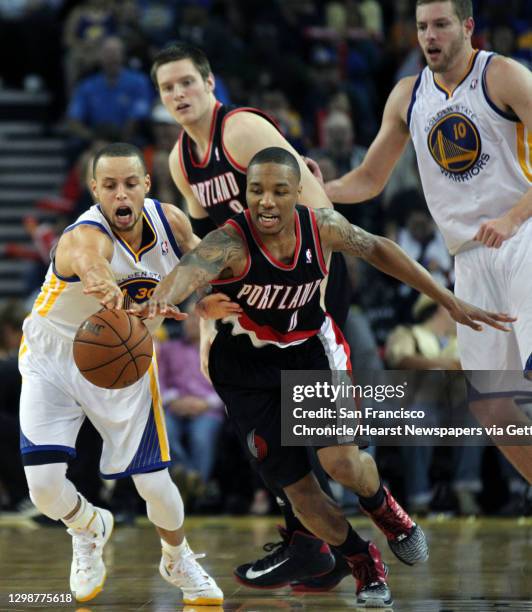 Golden State Warriors guard Stephen Curry fights Portland Trail Blazers Damian Lillard for control of the ball in the second half of their NBA...