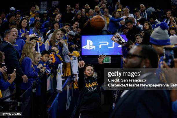 Golden State Warriors guard Stephen Curry shoots his pregame ritual three-point shot from the tunnel during warm up before an NBA basketball game...