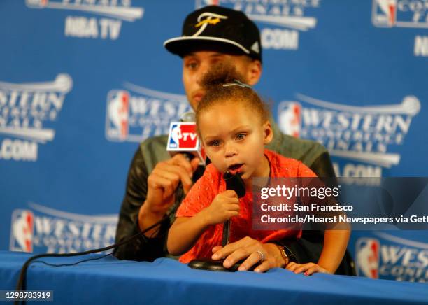 Golden State Warriors' Stephen Curry speaks to the media as his daughter Riley plays after Warriors' 104-90 win over Houston Rockets in Game 5 of NBA...