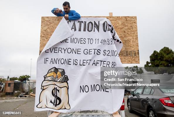 Laborer Property. Sign A day laborer hangs a sign offering money to residents of a homeless ...
