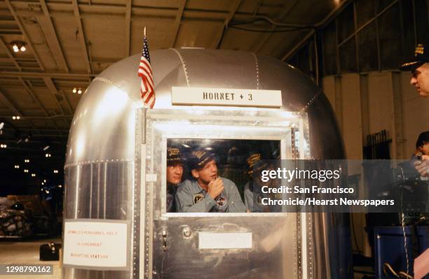 Apollo 11 astronauts Edwin Aldrin, Jr., left, Neil Armstrong, and Michael Collins are seen in quarantine in the Mobile Quarantine Facility as they...