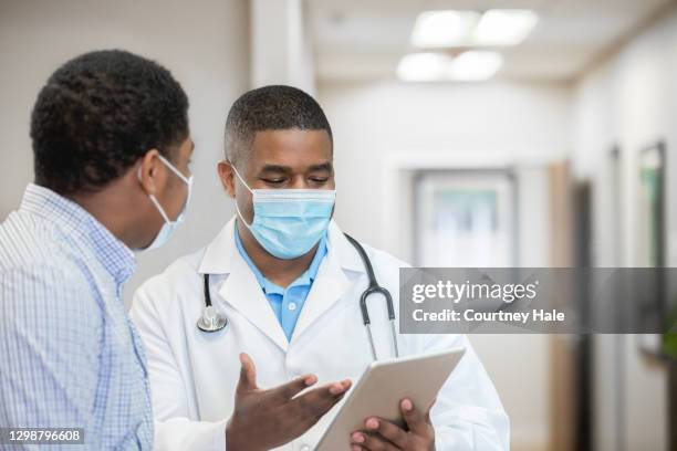 médico explicando los resultados de las pruebas al paciente - hombre revision fotografías e imágenes de stock