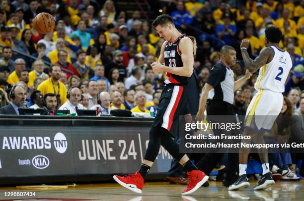 Portland Trail Blazers Zach Collins winces in pain in the fourth quarter during game 1 of the Western Conference Finals between the Golden State...