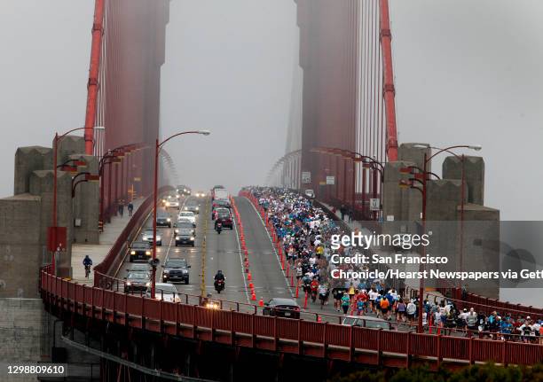 Runners crowded into the northbound lanes of the Golden Gate Bridge which they shared with regular Sunday morning traffic.The annual San Francisco...
