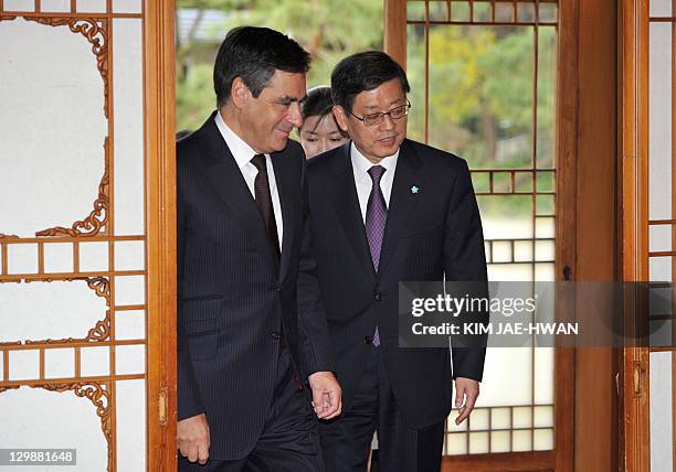 French Prime Minister Francois Fillon is welcomed by his South Korean counterpart Kim Hwang-Sik as they arrive for their lunch in Seoul on October...