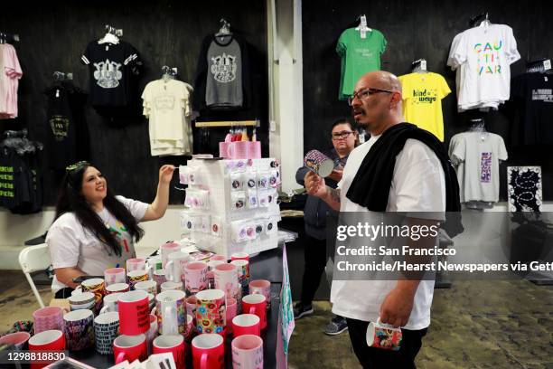 Nena Pinedo , owner of Hija de tu Padre, and customer Raquel J�uregui look at Ren� Qui�onez during a conversation at Movement Ink, in Oakland,...