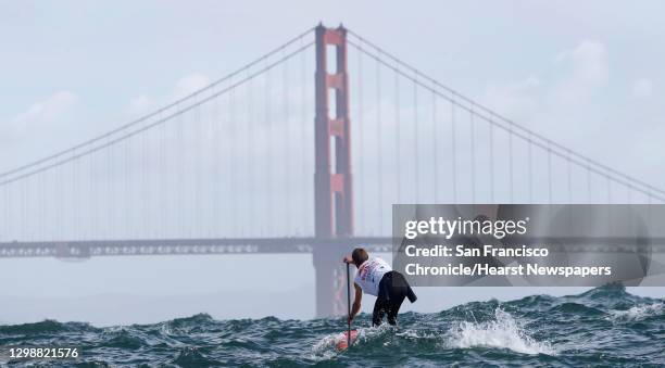 First place finisher Casper Steinfath approaches the Golden Gate Bridge during the Red Bull Heavy Water stand-up paddleboard race in San Francisco,...