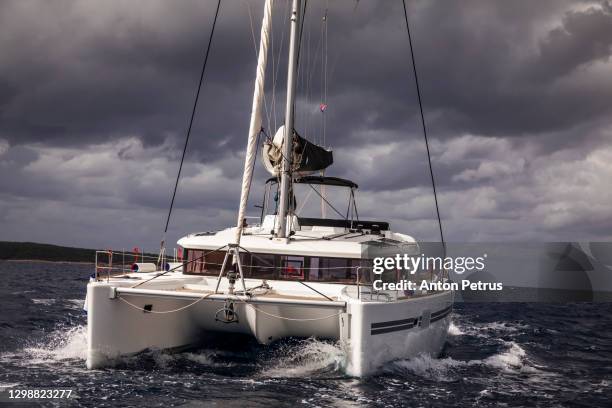 catamaran in a stormy sea in dramatic weather - catamaran race photos et images de collection