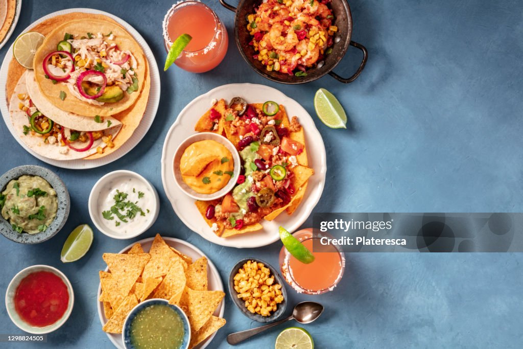 Mexican food, an overhead flat lay. Nachos, tacos, and other snacks