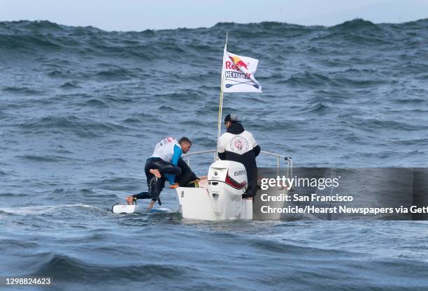 Race participant retreats to a rescue boat during the Red Bull Heavy Water stand-up paddleboard race in San Francisco, Calif. On Friday Oct. 20,...