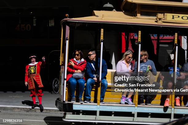 Sir Francis Drake hotel doorman Tom Sweeney greets a cable car as it rides past the hotel on Powell Street in San Francisco, California, on Thursday,...