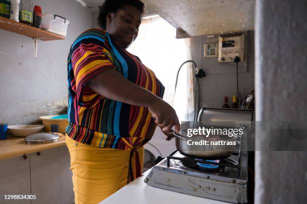 afrikanische frau kocht auf einem gasbrenner - gas cooking stock-fotos und bilder