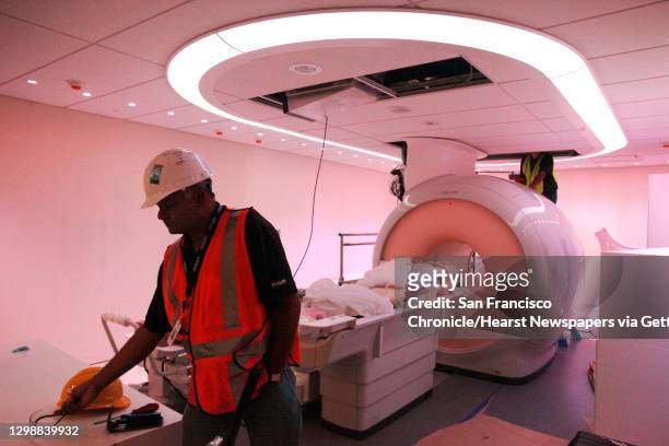 Philips field service engineers Kirit Patel, left, and Ron Witschy work in the partially-finished Philips MRI room, which offers the ""ambient""...