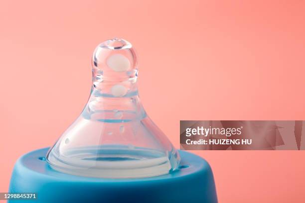 close-up of pacifier on baby bottle - おしゃぶり ストックフォトと画像