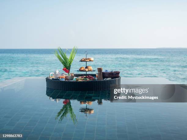 floating breakfast on infinity pool in luxury hotel - island villa stock pictures, royalty-free photos & images