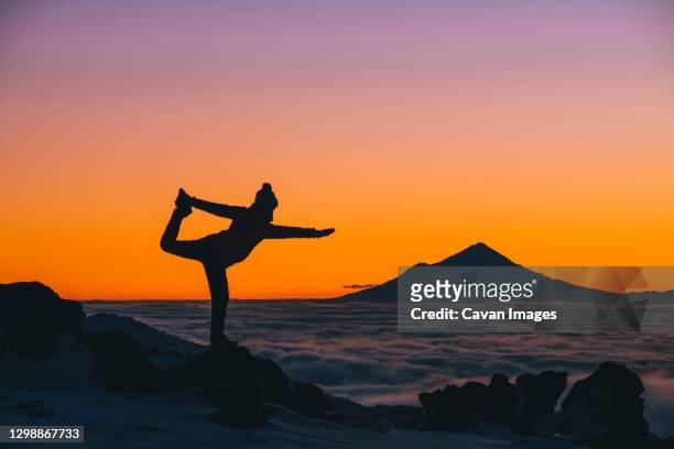 young woman on yoga pose during sunset with mt taranaki in the background, tongariro national park, new zealand - ski new zealand stock pictures, royalty-free photos & images