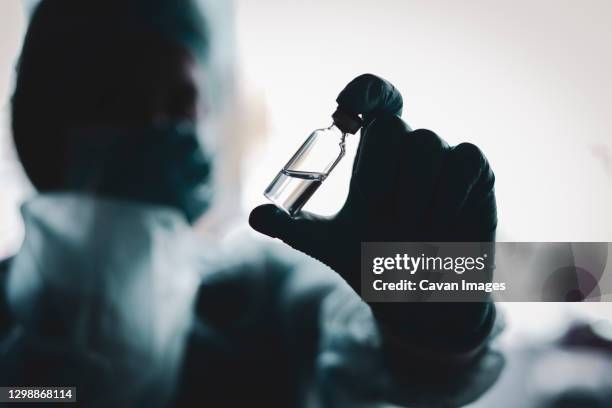 medical doctor or laborant holding tube with ncov coronavirus vaccine for 2019-ncov virus. - laborant stock pictures, royalty-free photos & images