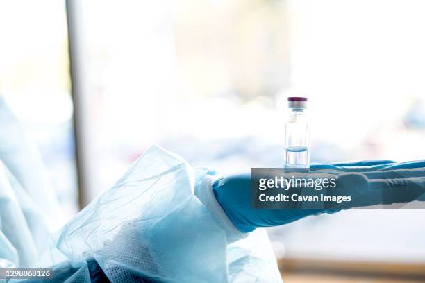 medical doctor or laborant holding tube with ncov coronavirus vaccine for 2019-ncov virus. - laborant stock pictures, royalty-free photos & images