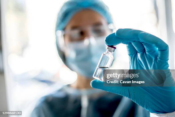 medical doctor or laborant holding tube with ncov coronavirus vaccine for 2019-ncov virus. - laborant stock pictures, royalty-free photos & images