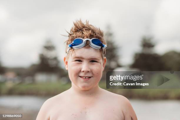smiling boy at the beach with goggles on the top of his head - 12 ears stock pictures, royalty-free photos & images