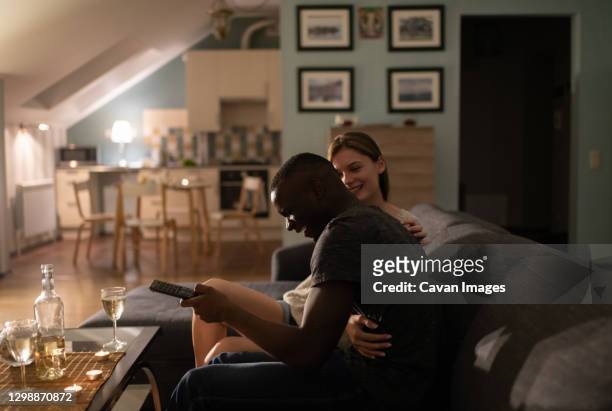 excited diverse couple watching tv - couple watching tv photos et images de collection