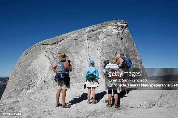 Early in the morning before the crowds arrived, a group of hikers look at the Half Dome cable section in Yosemite National Park on June 30, 2007.